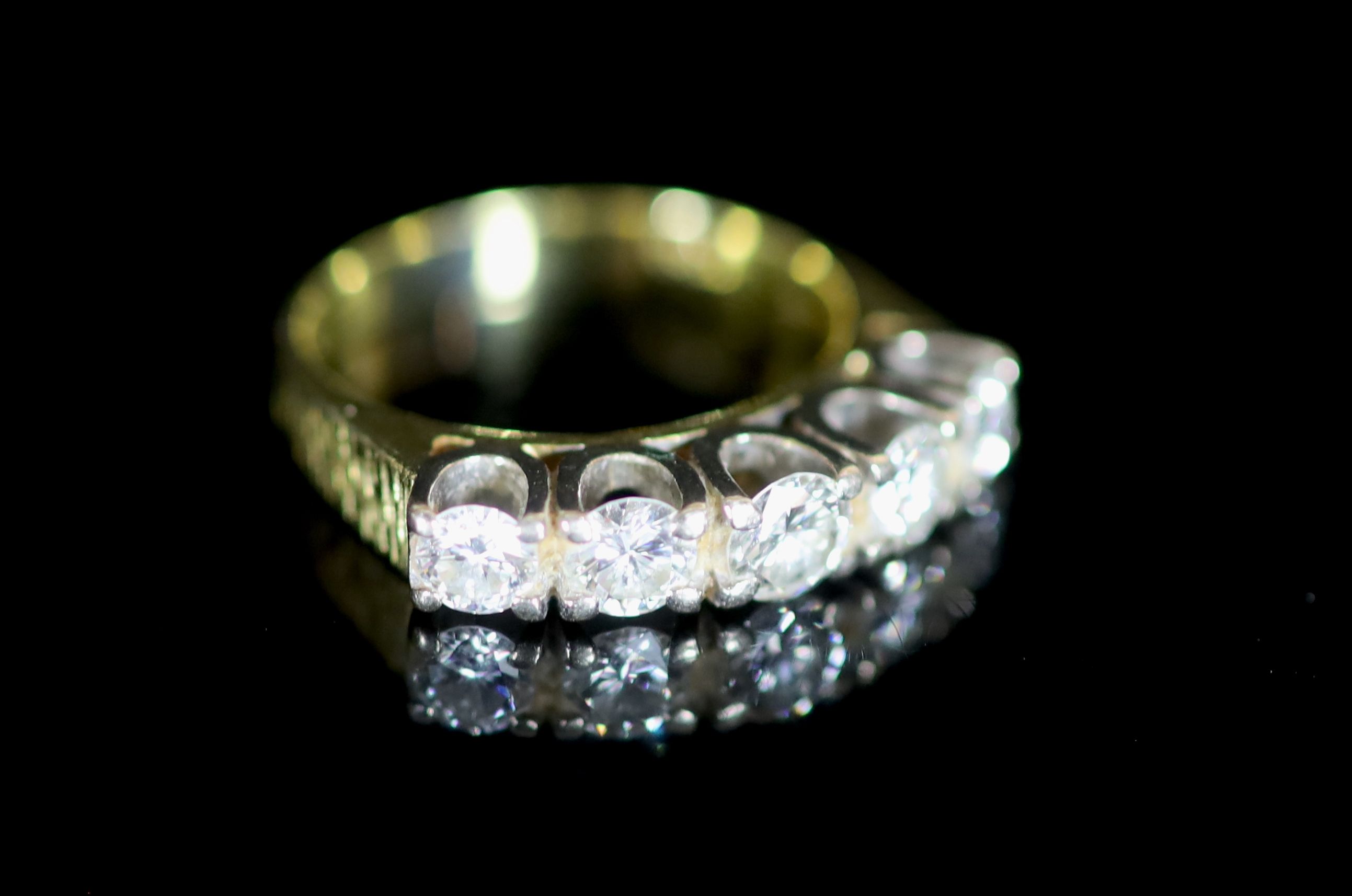 A modern 18ct gold and graduated five stone diamond set half hoop ring